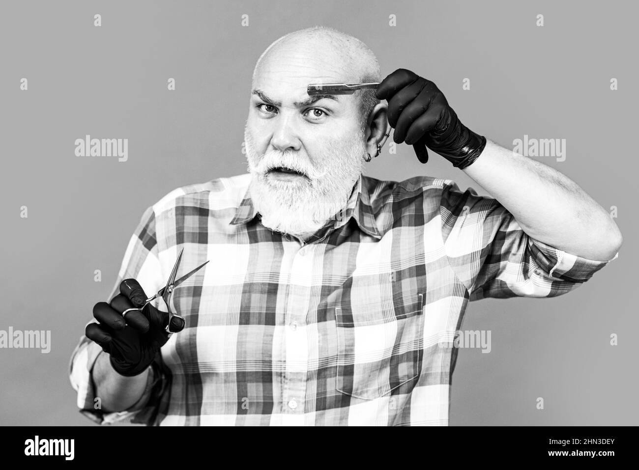 Mature barber with scissors and razor. Vintage shaving