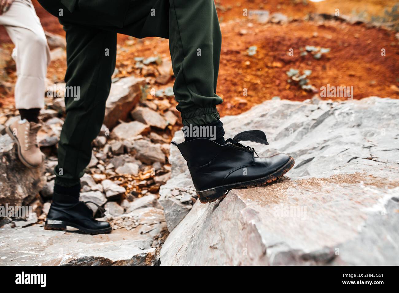 Girls in a post-apocalyptic place, a quarry with red earth and stones in work clothes Stock Photo