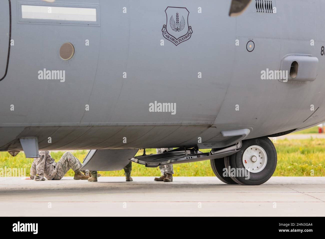 Otopeni, Romania - May 20, 2014: US Air Forces soldiers near a military cargo plane on the taxiway of a military airport. Stock Photo