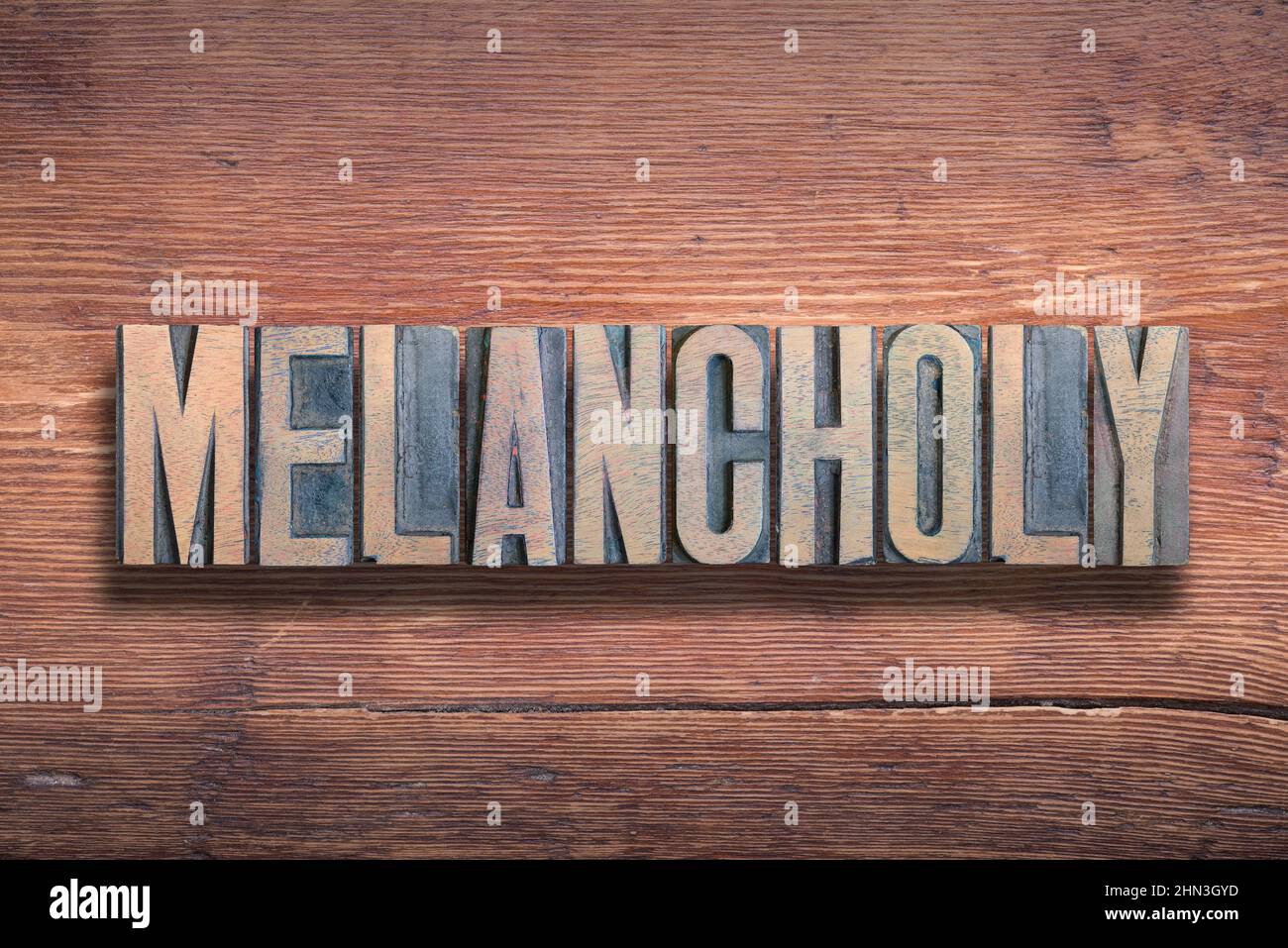 melancholy word combined on vintage varnished wooden surface Stock Photo