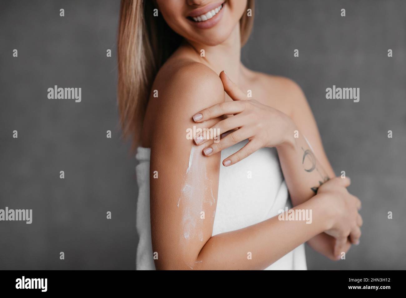 Closeup or woman applying moisturizing body lotion on shoulder, using nourishing cream for skin Stock Photo