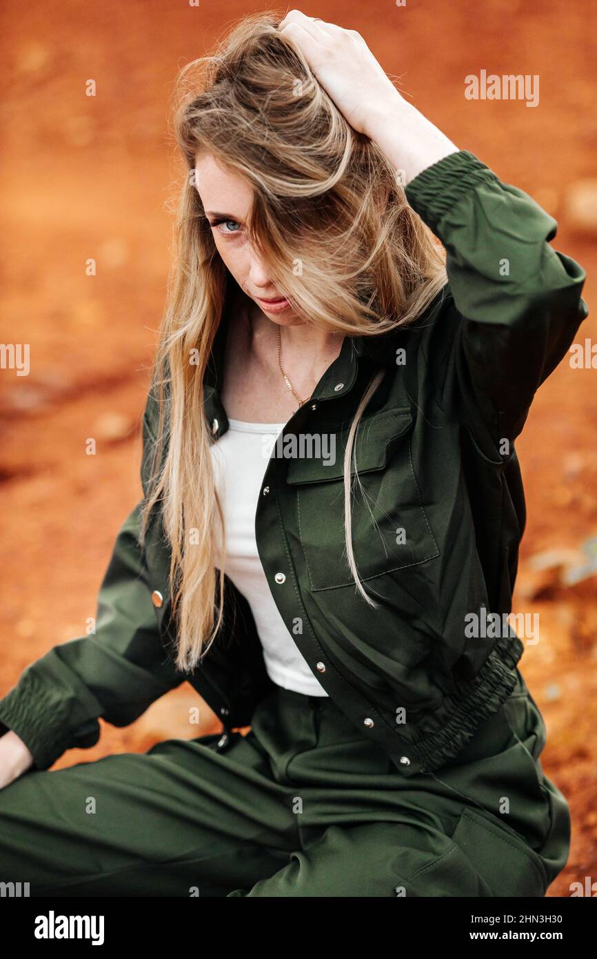 Girls in a post-apocalyptic place, a quarry with red earth and stones in work clothes Stock Photo