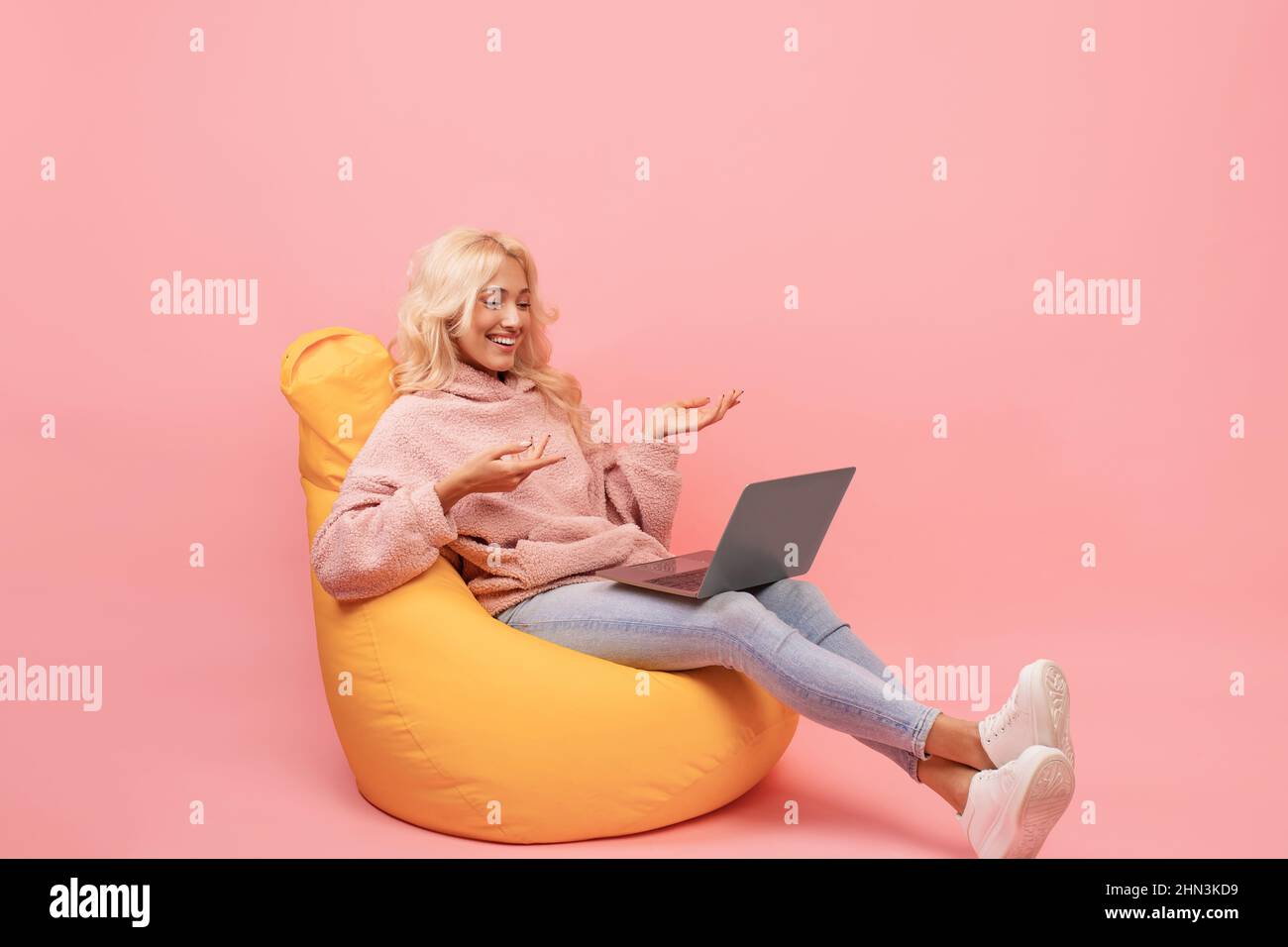 https://c8.alamy.com/comp/2HN3KD9/happy-woman-making-video-call-on-laptop-while-sitting-in-beanbag-chair-emotionally-talking-at-computer-screen-2HN3KD9.jpg
