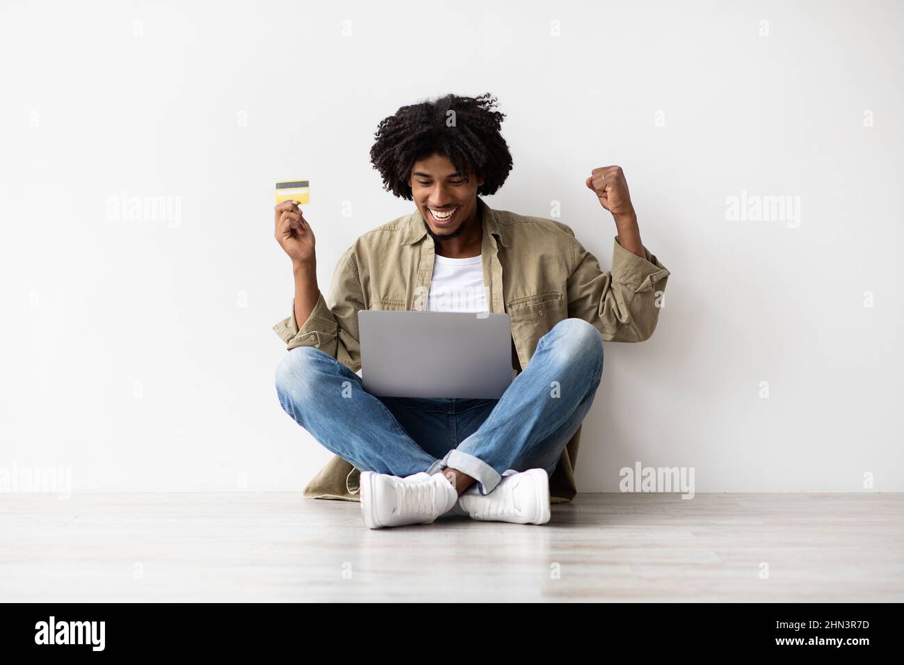 E-Commerce Concept. Portrait Of Excited Black Guy With Laptop And Credit Card Stock Photo