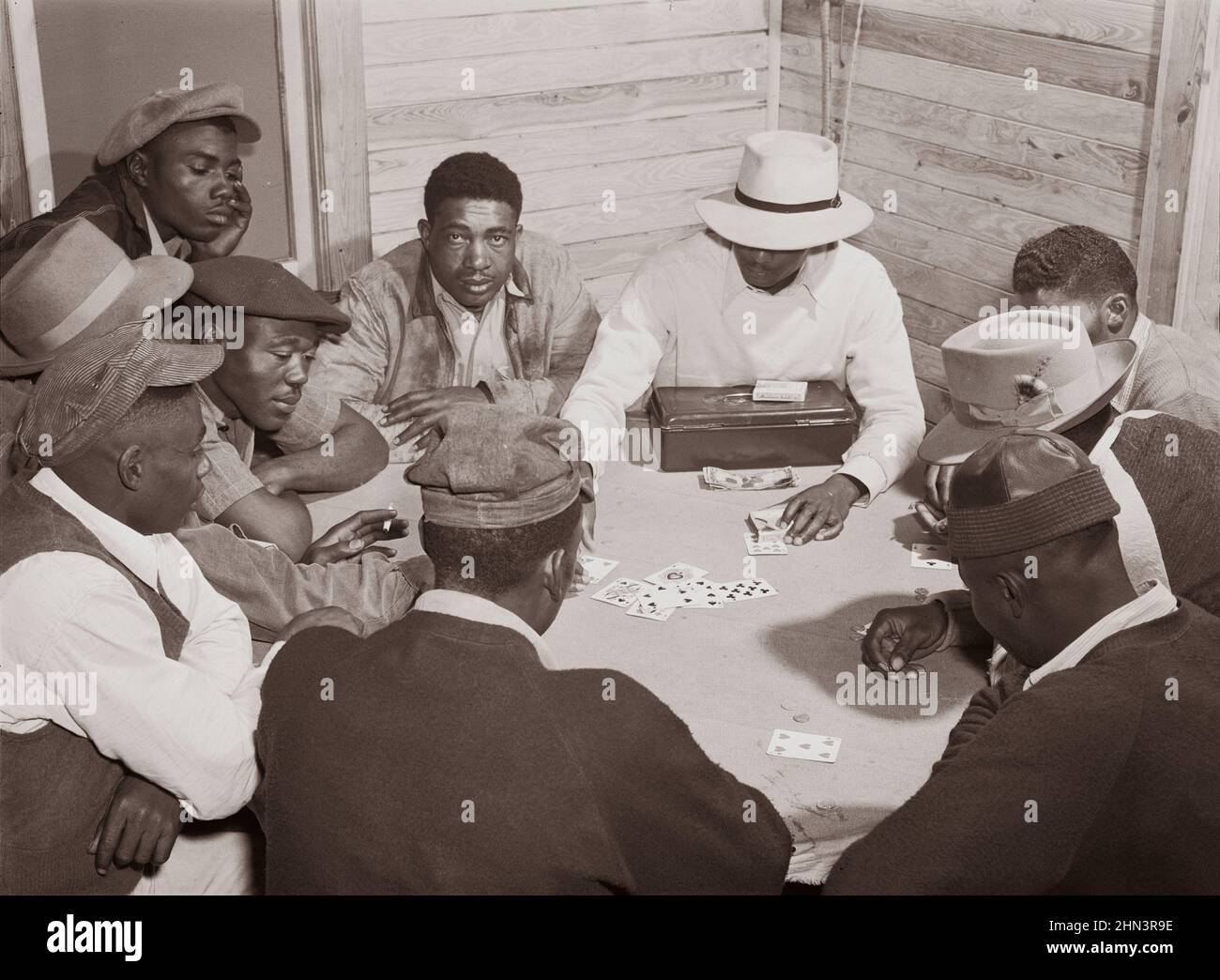 Vintage photo of American South in 1940s. Migratory laborers and vegetable pickers playing 'skin' game in back of juke joint and bar in the Belle Glad Stock Photo