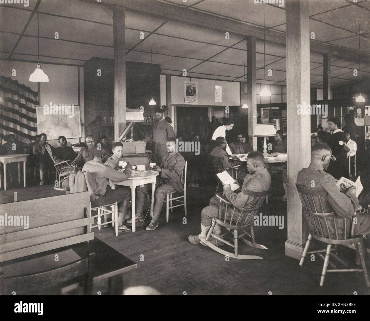 Vintage photo of African American soldiers reading, playing cards, and relaxing in Y.W.C.A. Hostess House. 1918 Stock Photo