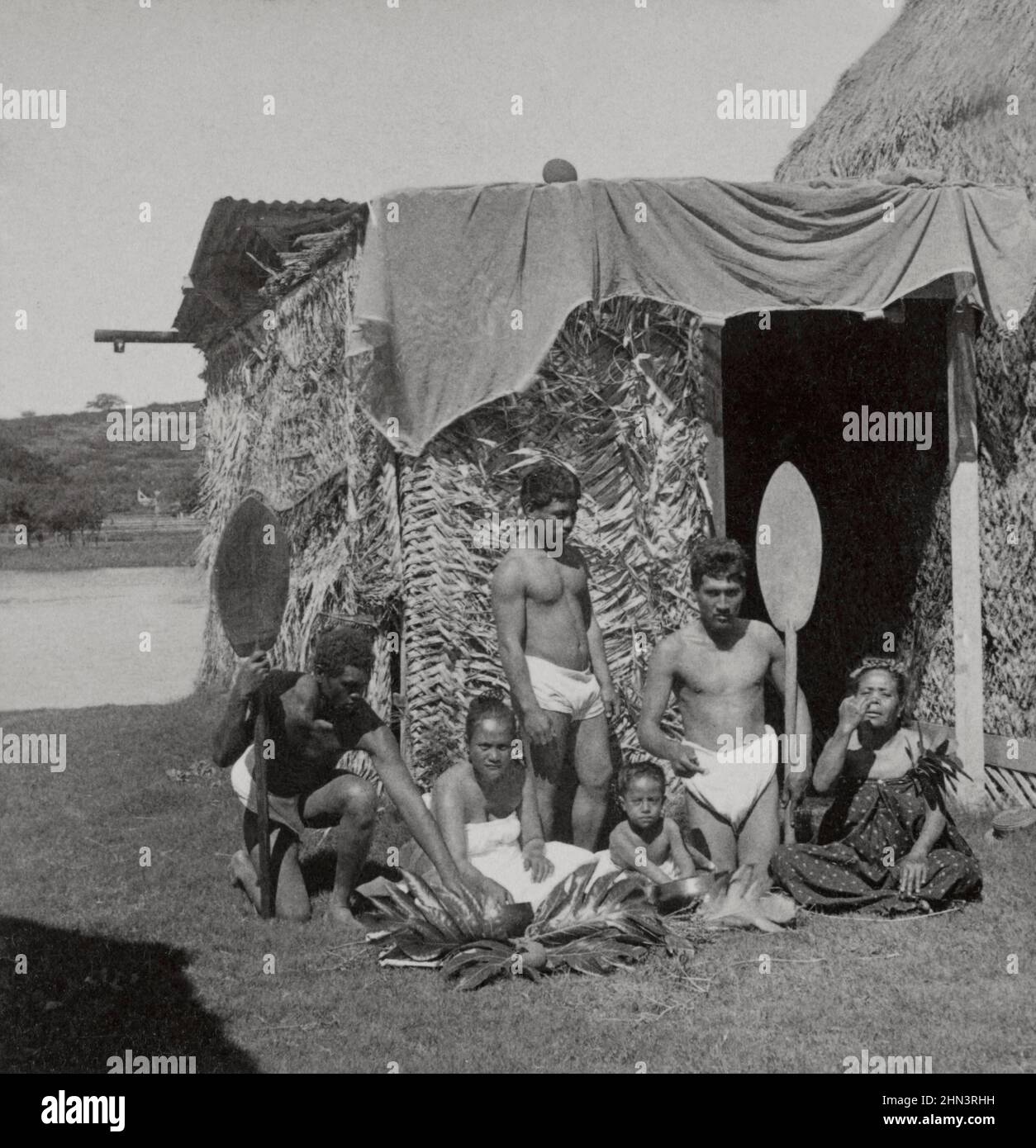 Vintage photo of group of Native Kanaka Maoli eating poi, Hawaiian Islands (in front of grass hut). 1896 Native Hawaiians are the Indigenous Polynesia Stock Photo
