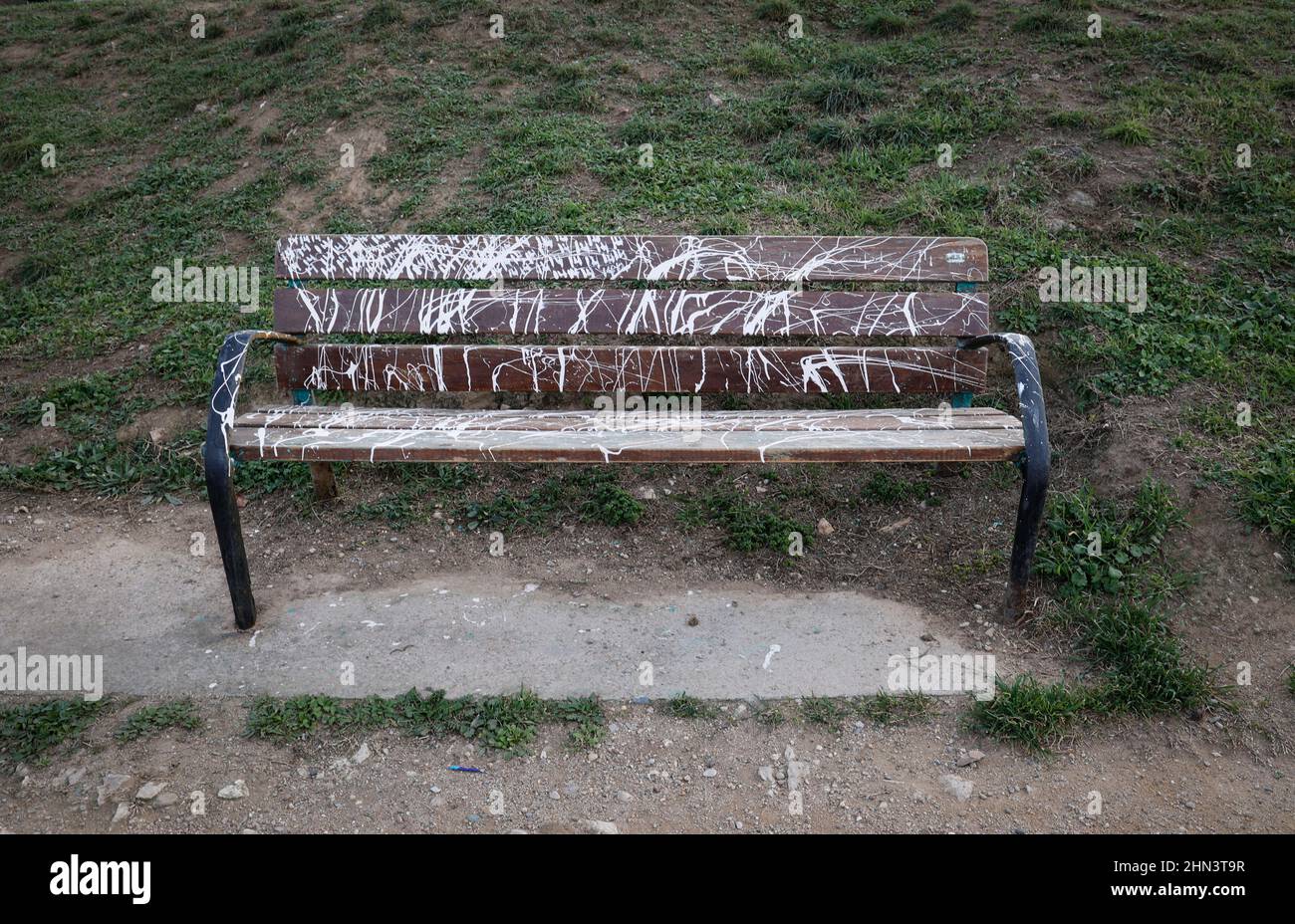 Vandalised bench covered in spray paint Stock Photo