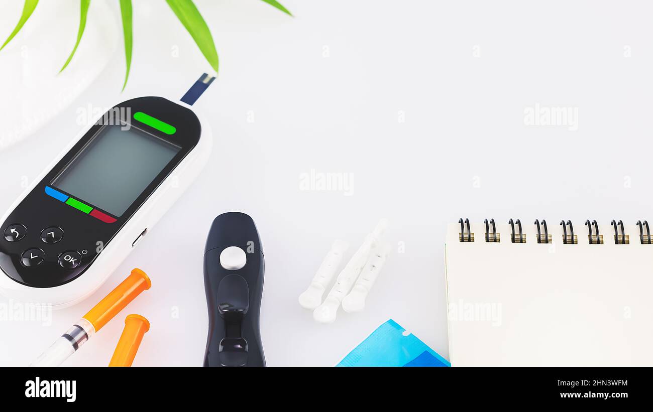 Diabetes control. Diabetic disease concept with Glucose meter, test strips for determining blood sugar levels, lancets and insulin syringes on a white Stock Photo