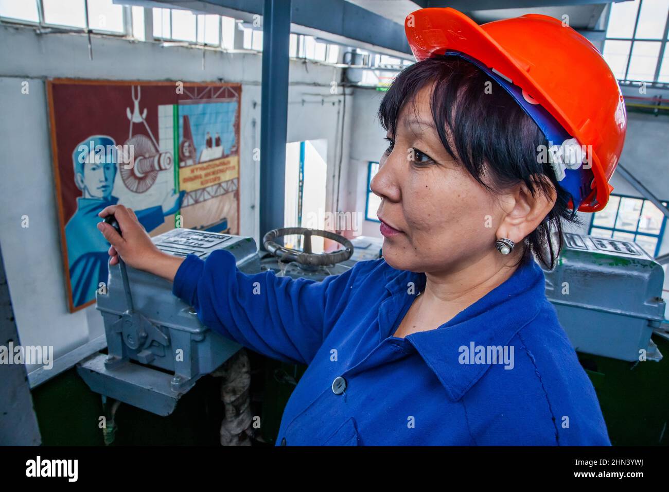 Kazaly, Kazakhstan - May 02, 2012: Locomotive repair plant. Asian woman crane operator in work. Stock Photo
