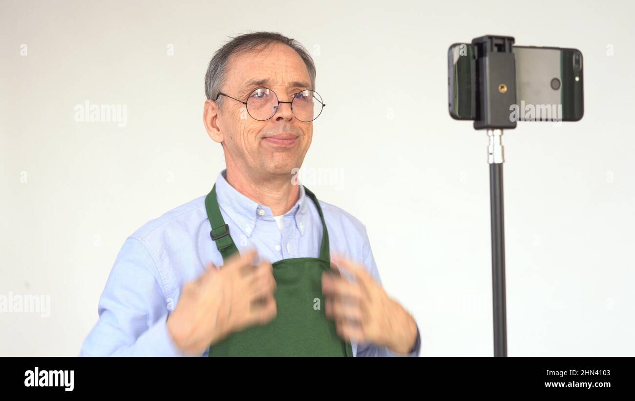 An elderly male blogger is broadcasting Stock Photo