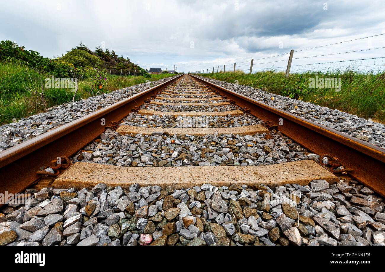 Railway tracks point towards infinity. Linear railroad goes in a straight direction. Purpose concept, personal growth or path and destiny illustration Stock Photo