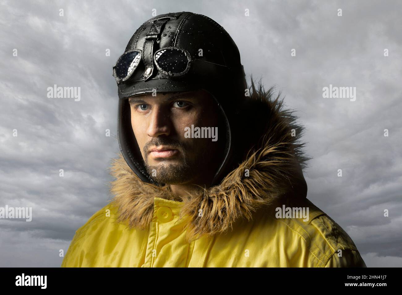 Portrait confident, serious male pilot in leather cap and parka Stock Photo