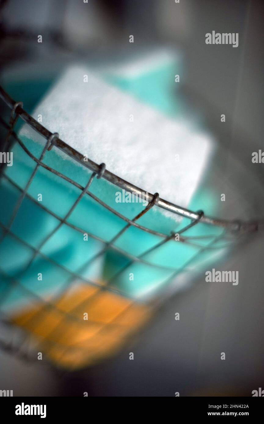 Washing-up sponges in wire basket Stock Photo