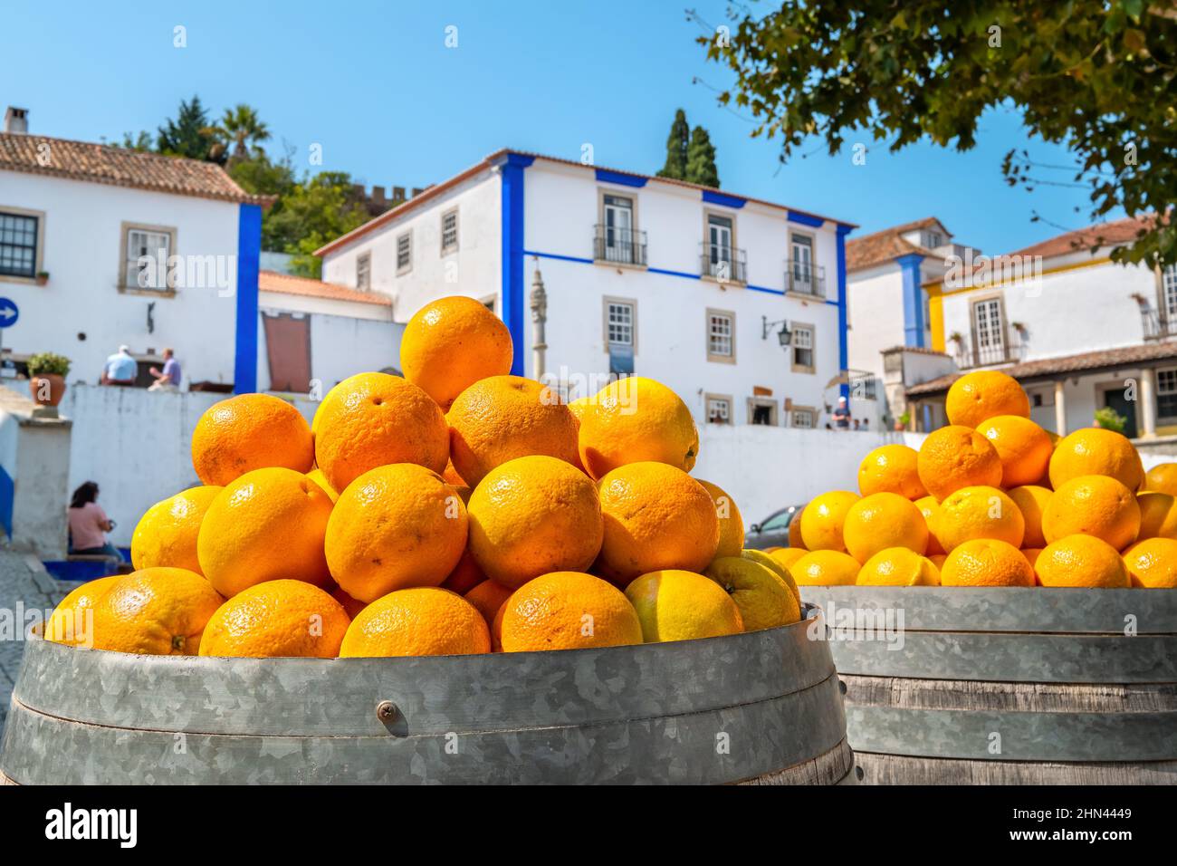Heap of ripe oranges in a wooden barrels. Obidos, Leiria District, Portugal. Selective focus Stock Photo