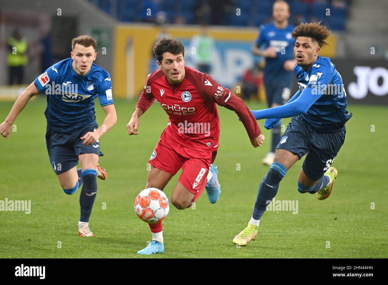 Sinsheim, Deutschland. 13th Feb, 2022. Alessandro SCHOEPF (BI), action,  duels versus Georginio RUTTER (1899 Hoffenheim) and Dennis GEIGER (1899  Hoffenheim, li). Soccer 1st Bundesliga season 20212022, 22.matchday,  matchday22. TSG 1899 Hoffenheim Arminia