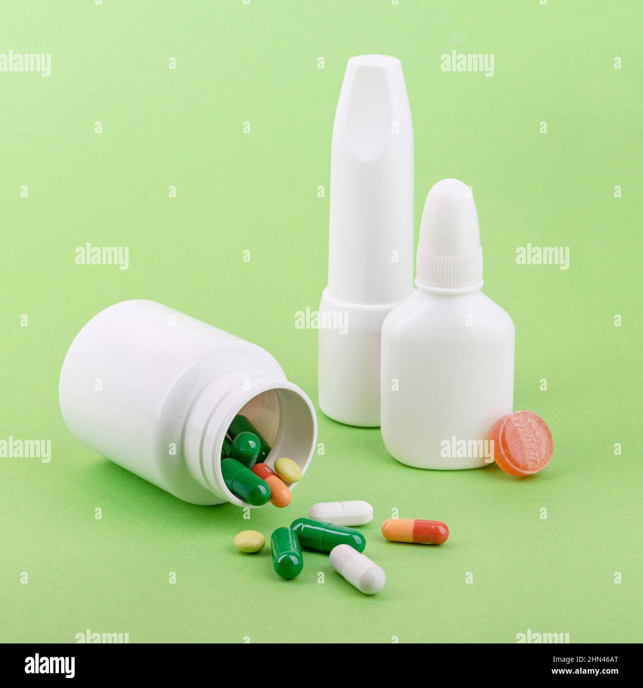 Medicine bottles and pills for respiratory disease therapy. Green background. Stock Photo
