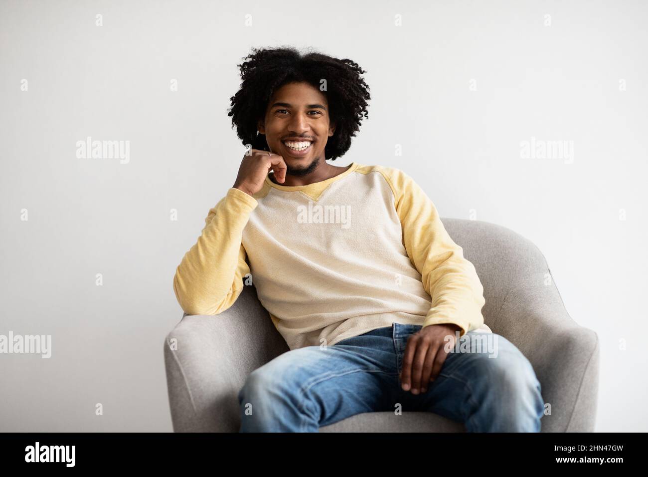Handsome Young Black Guy Sitting In Armchair And Smiling To Camera ...
