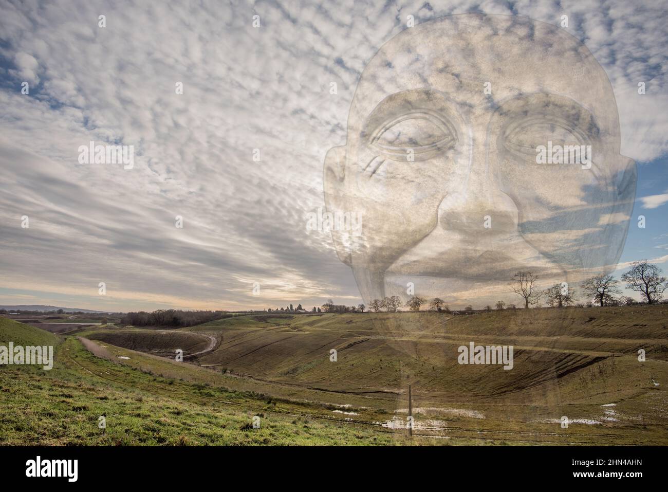 Double exposure photograph featuring Sandbach sand quarry and a cast head. Arclid sand quarry with a difference! Mackerel sky at Sandbach. Stock Photo
