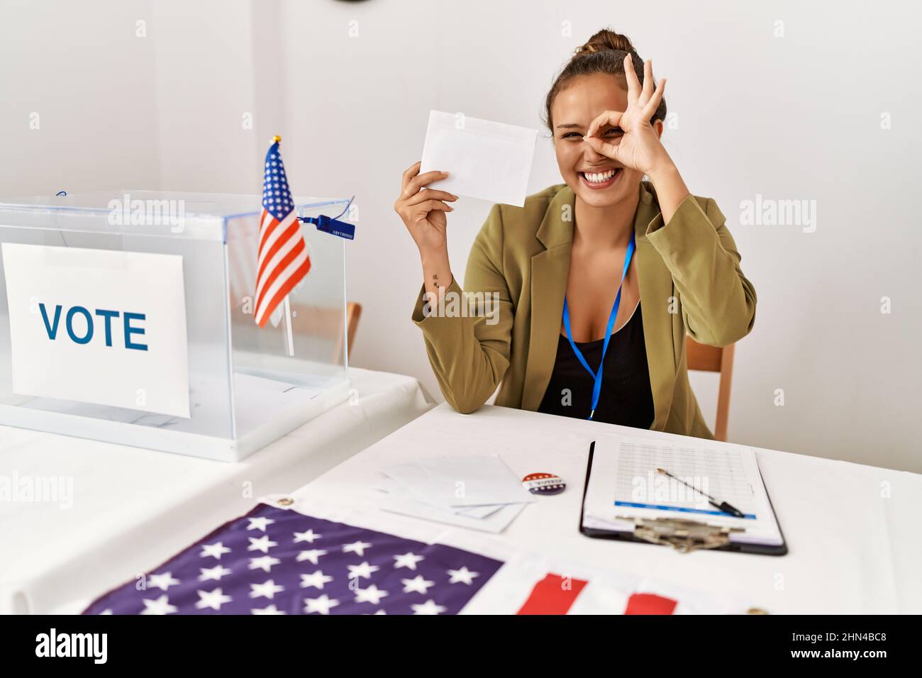 Beautiful Hispanic Woman Holding Voting Envelop In Ballot Box Smiling