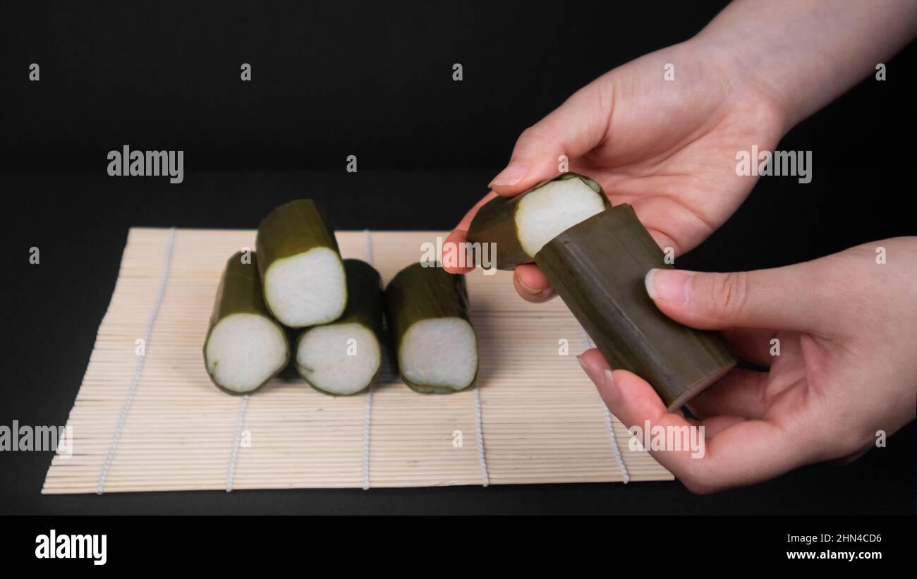 hands splitting Indonesian rice cake into to pieces Stock Photo Alamy