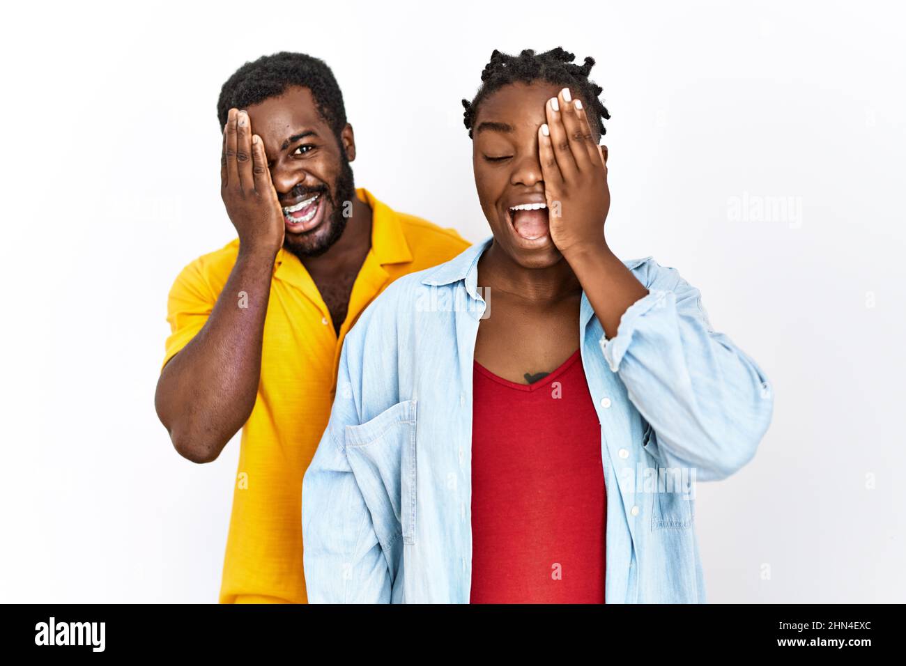 Young african american couple wearing casual clothes covering one eye ...