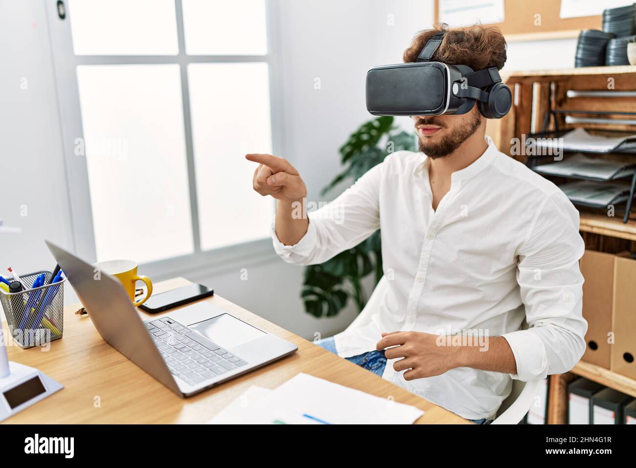 Young arab man using vr goggles working at office Stock Photo