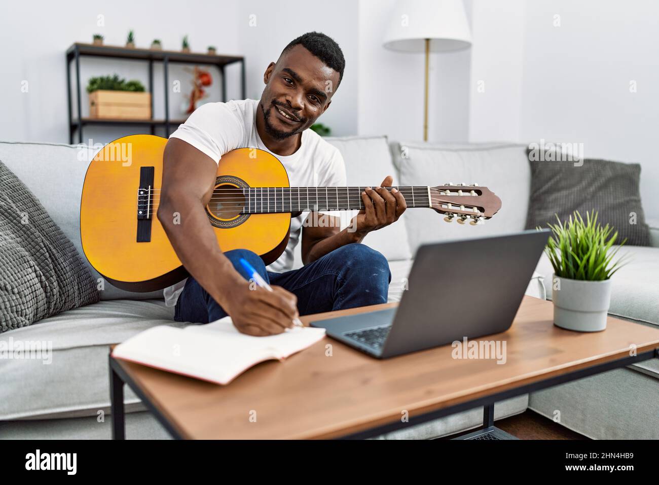 Young african american man smiling confident playing guitar at home ...