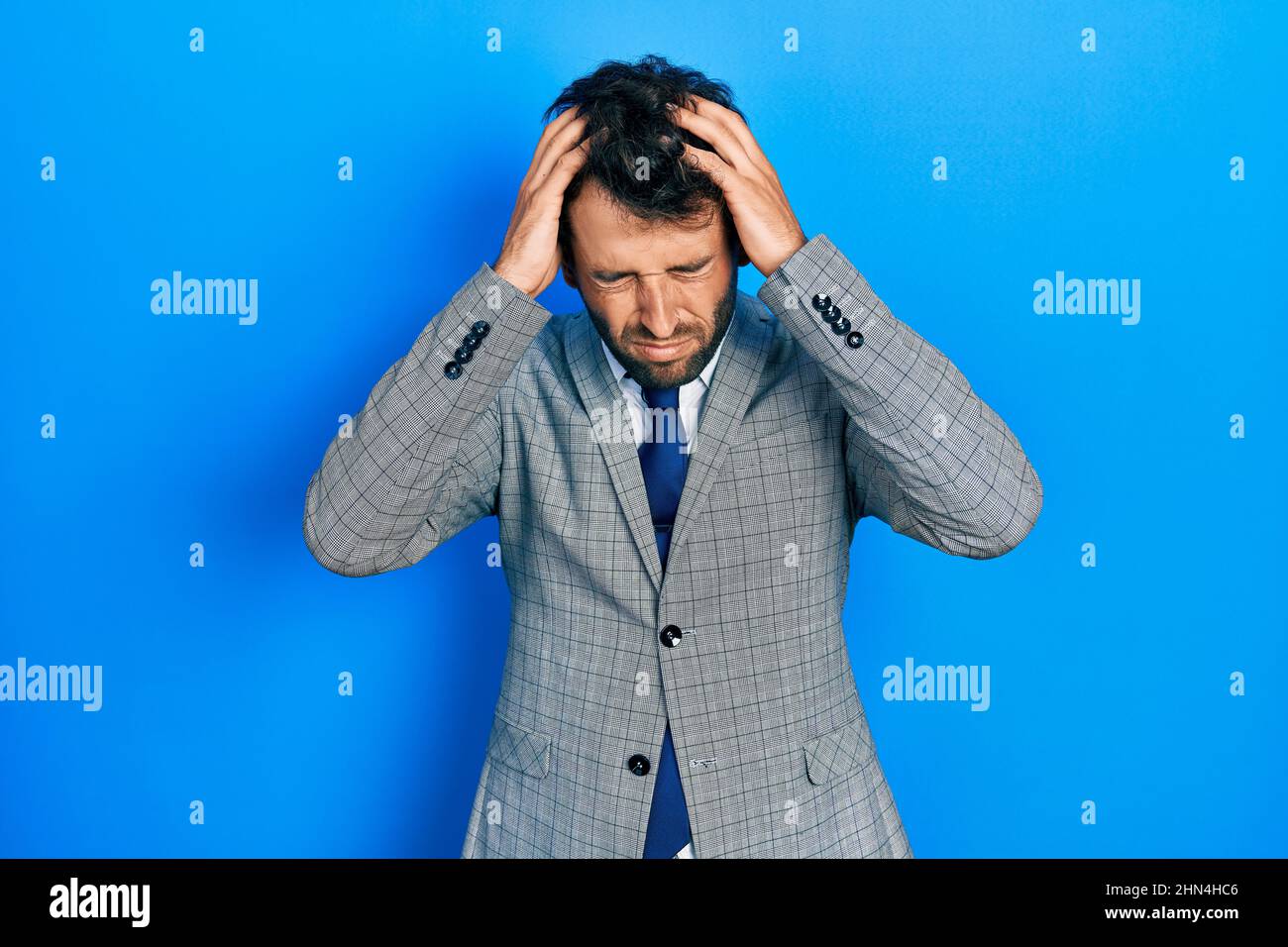 Handsome man with beard wearing business suit and tie suffering from ...
