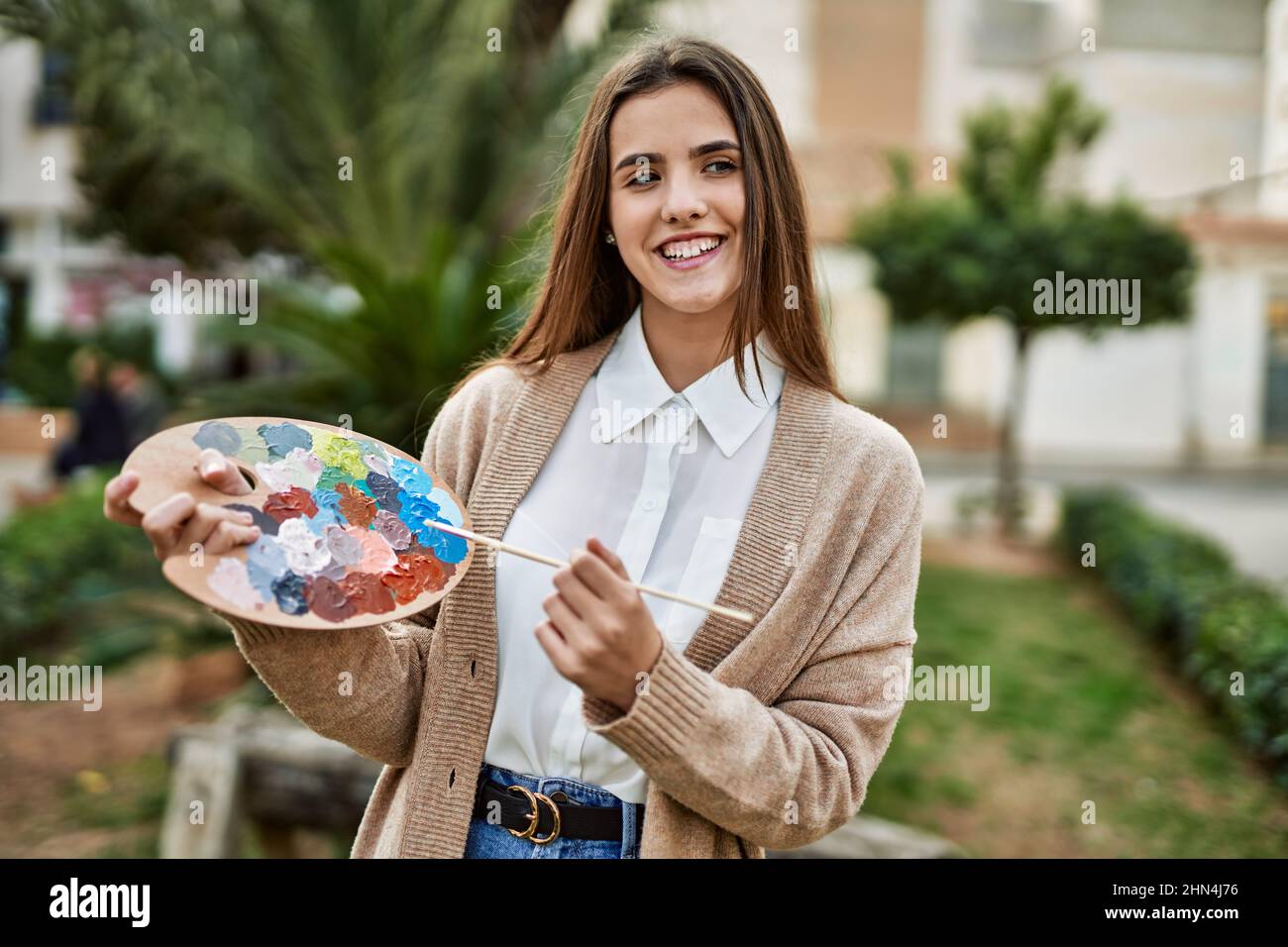 Young hispanic artist girl smiling happy painting at the city Stock ...