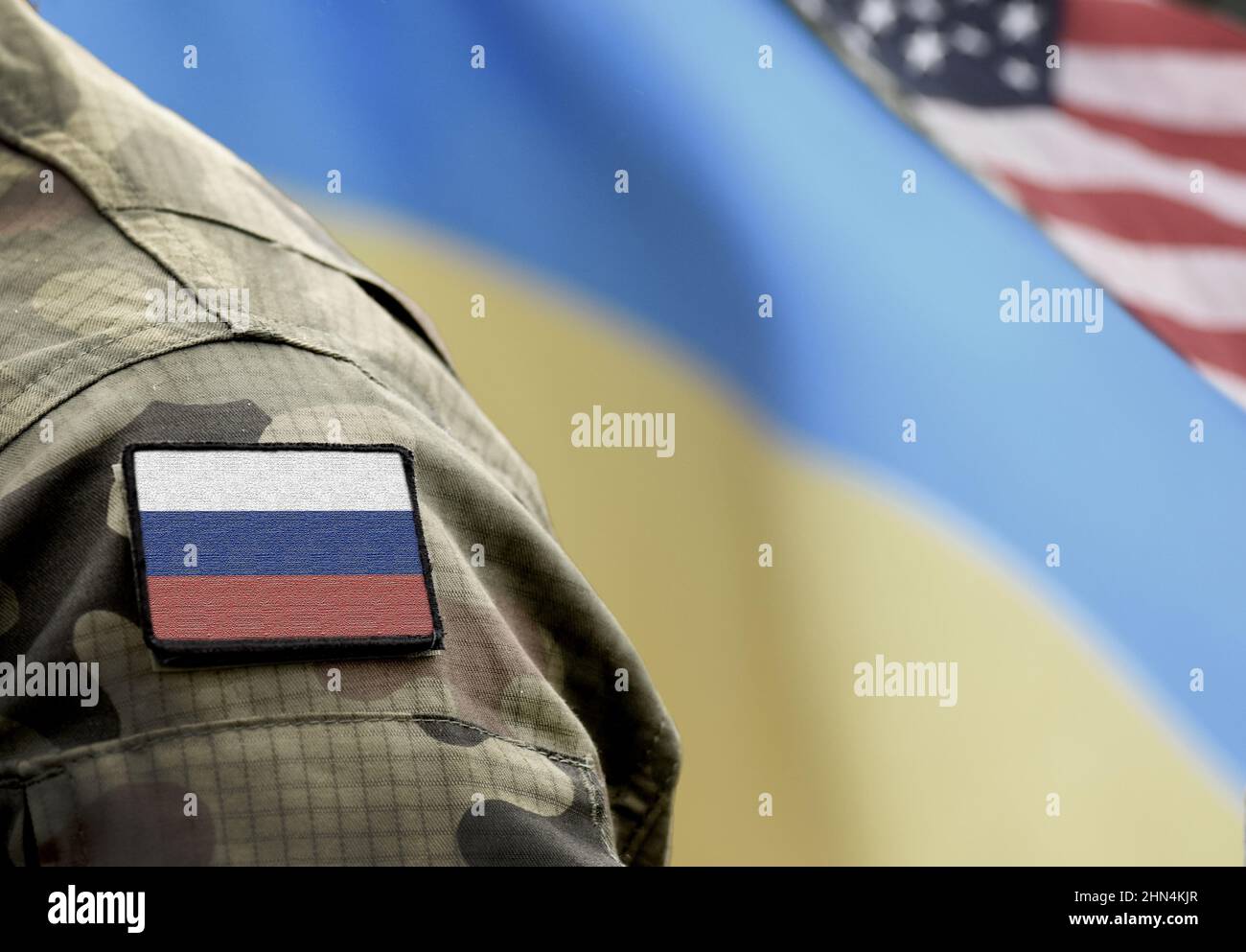 Flag of Russia on military uniform and flags of the Ukraine and USA at background. Russia VS Ukraine. Stock Photo