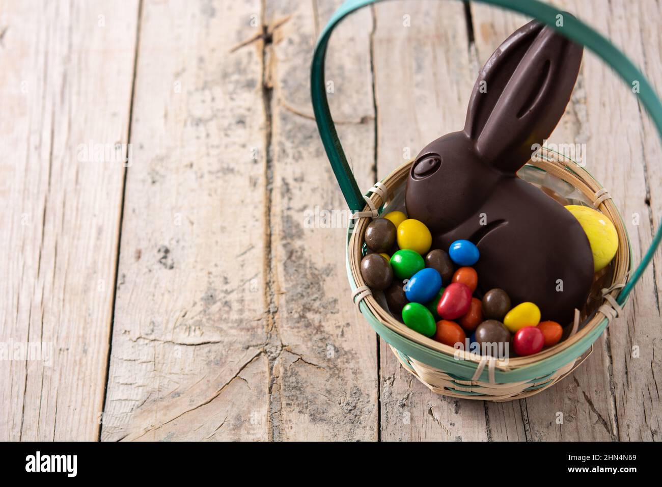 Easter chocolate bunny and colorful eggs on wooden table Stock Photo