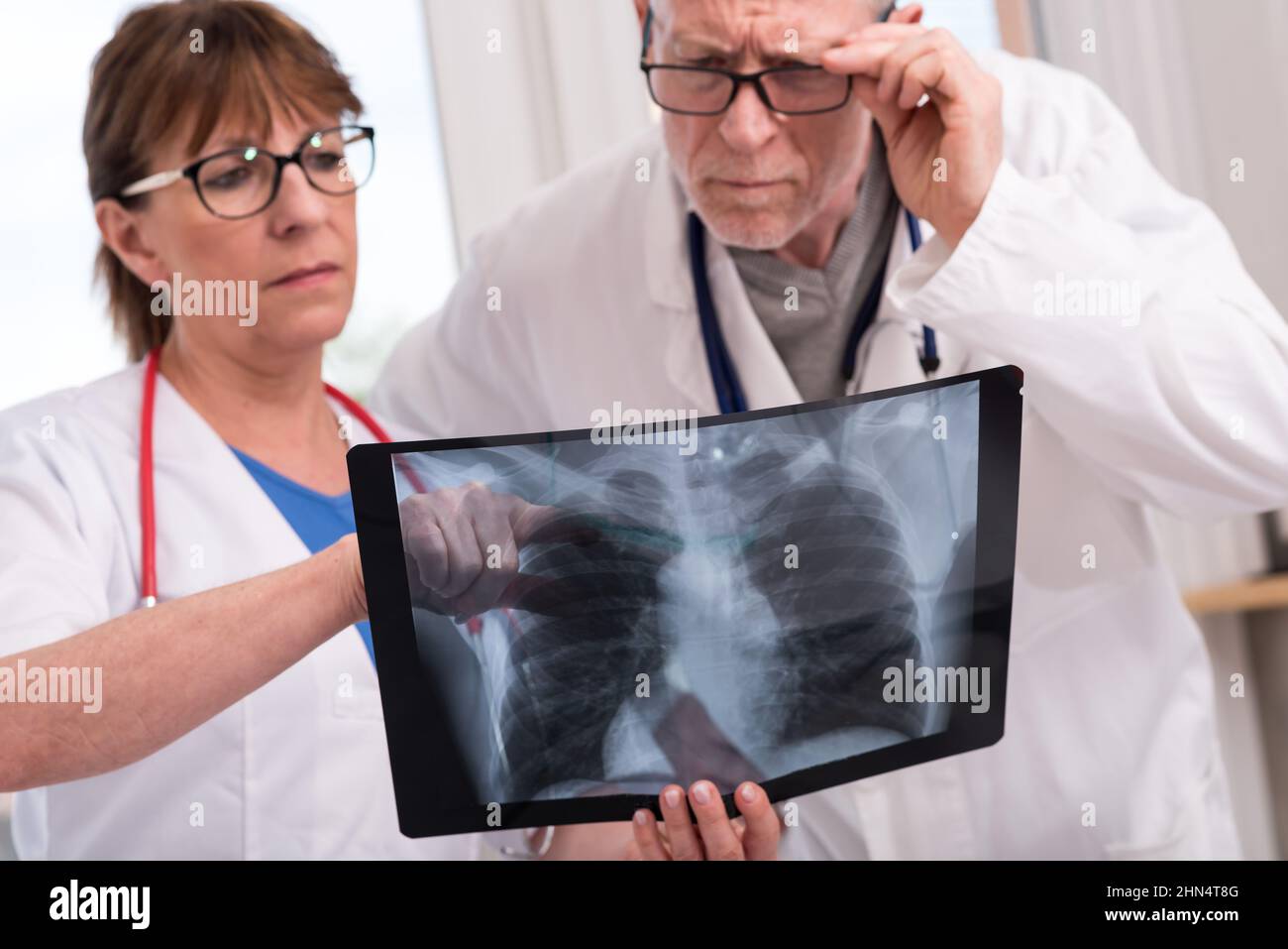 Two doctors examining xray report in medical office Stock Photo Alamy