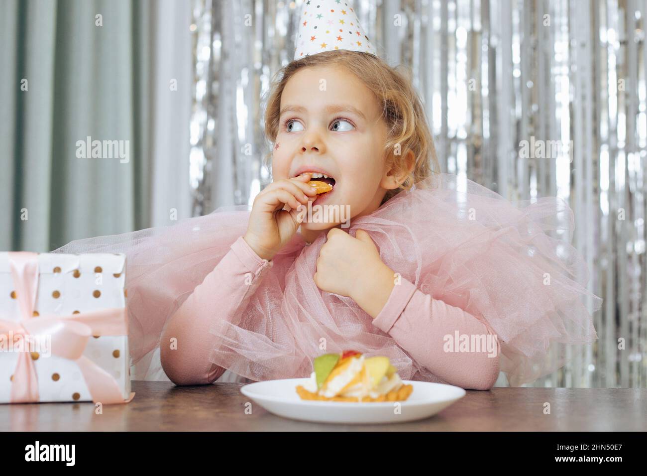 Little girl with short curly hair and stars on face in pink poofy dress ...