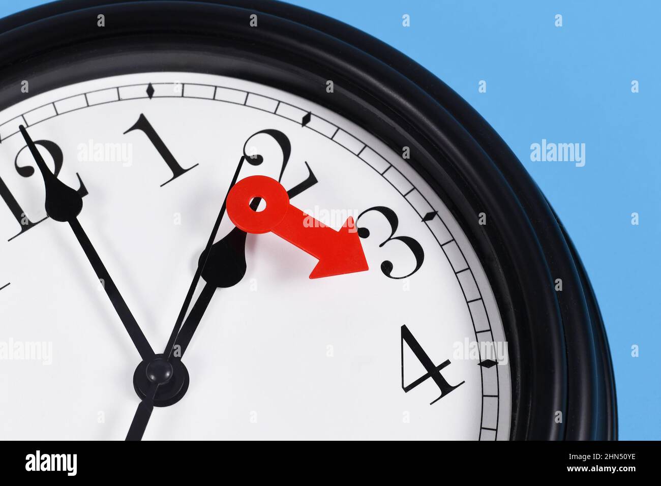 Summer time change for daylight saving in Europe concept. Red arrow symbolizing clock turned forward by one hour Stock Photo