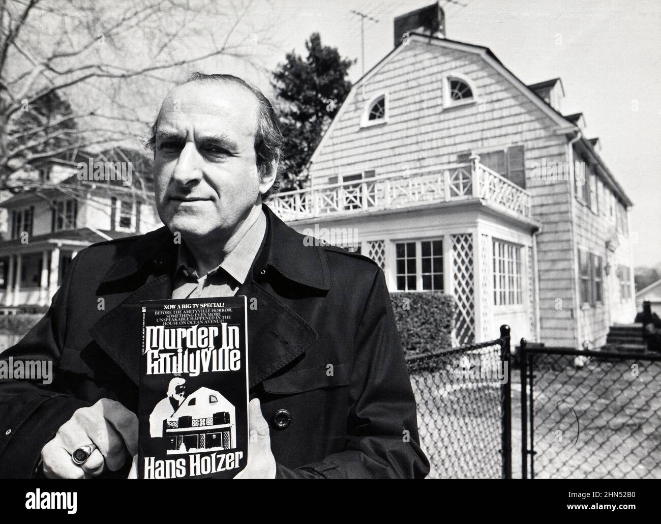 Posed portrait of the late Austrian American author and Parapsychologist Hans Holzer in front of the infamous Amityville Horror House. He investigated the paranormal, ghosts & haunted houses. His book debunked the claims in the popular 1979 move, 'The Amityville Horror.' In Amityville, Long Island, 1980. Stock Photo