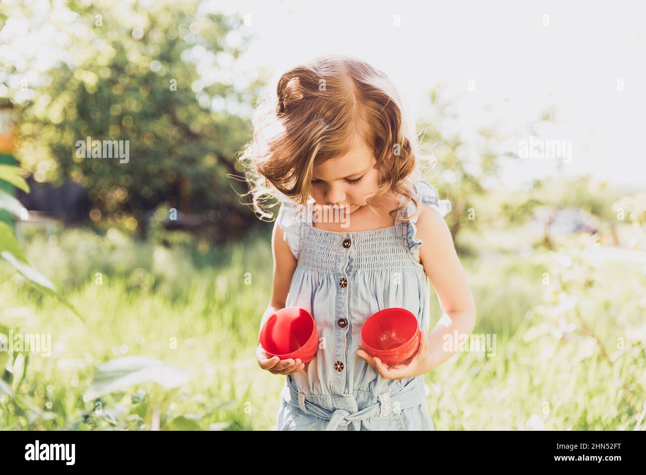 Easter egg hunt. Girl child Wearing Bunny Ears Running To Pick Up Egg