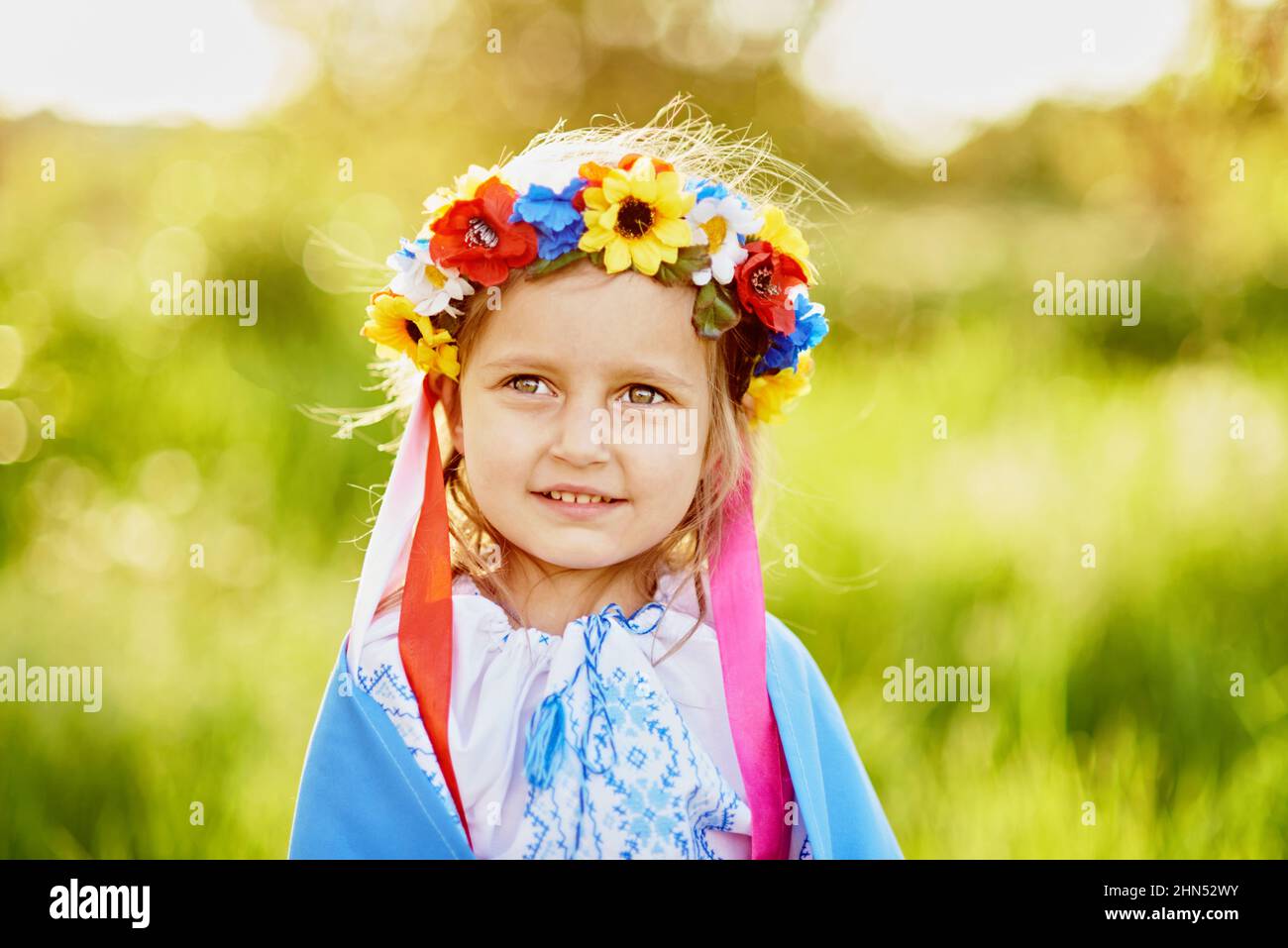 Ukraines Independence Flag Day. Constitution day. Ukrainian child girl in embroidered shirt vyshyvanka with yellow and blue flag of Ukraine in field. Stock Photo