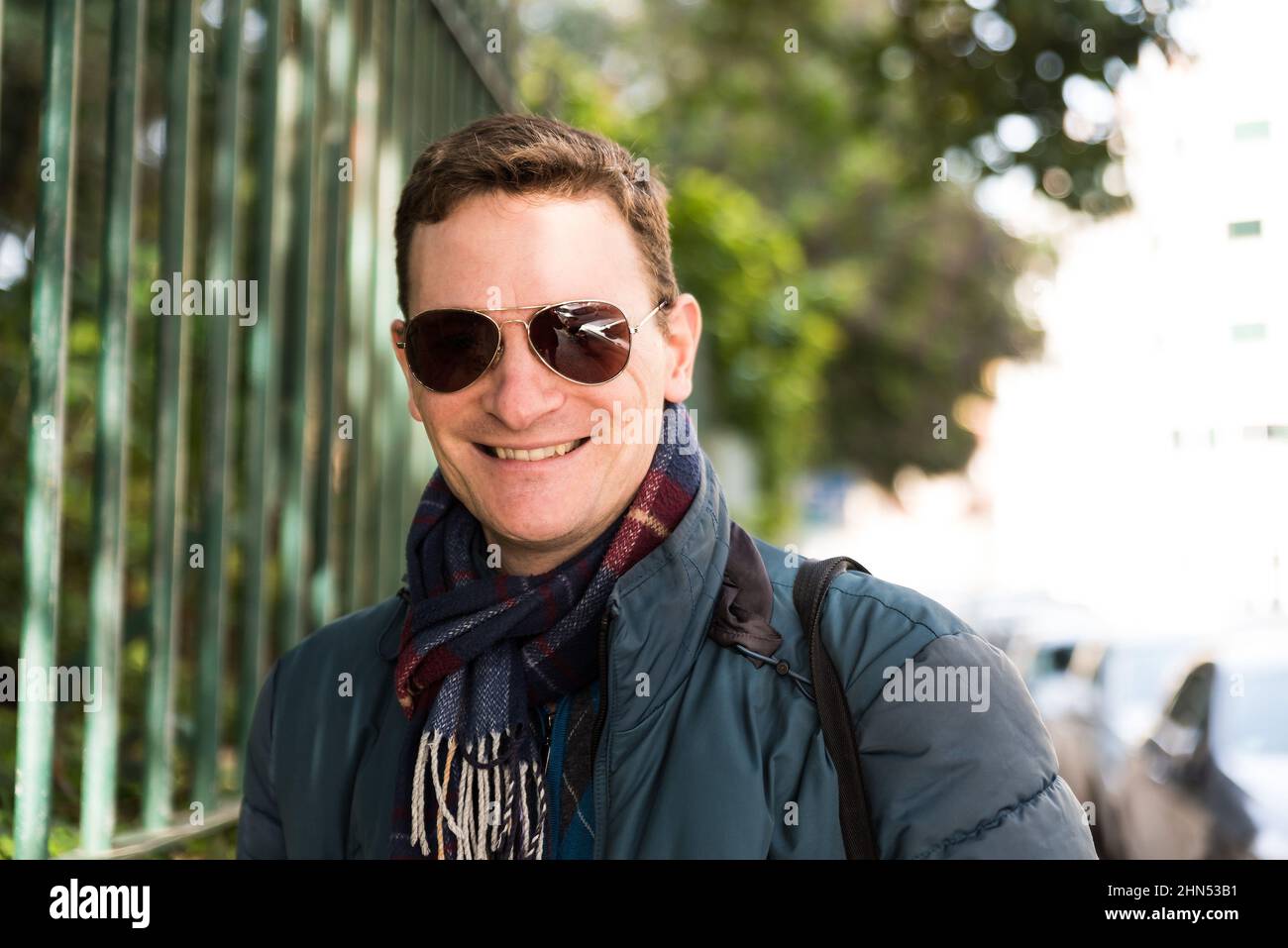 trait of a confident 40 year old white man with a scarf and sunglasses Stock Photo