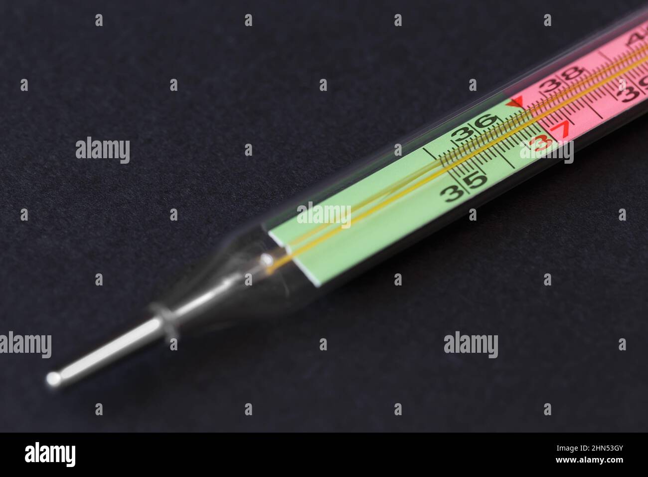Mercury thermometer with a two-color scale on a dark background. Close-up with shallow depth of field Stock Photo