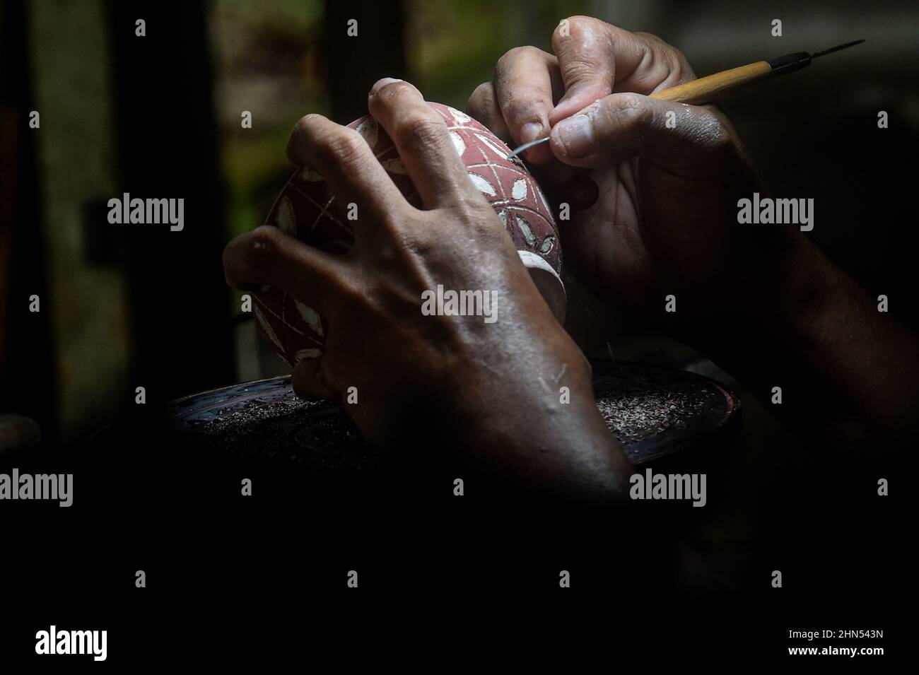 West Java, Indonesia. 14th Feb, 2022. A craftsman carves a pottery at a workshop in Depok, West Java, Indonesia, Feb. 14, 2022. Credit: Agung Kuncahya B./Xinhua/Alamy Live News Stock Photo