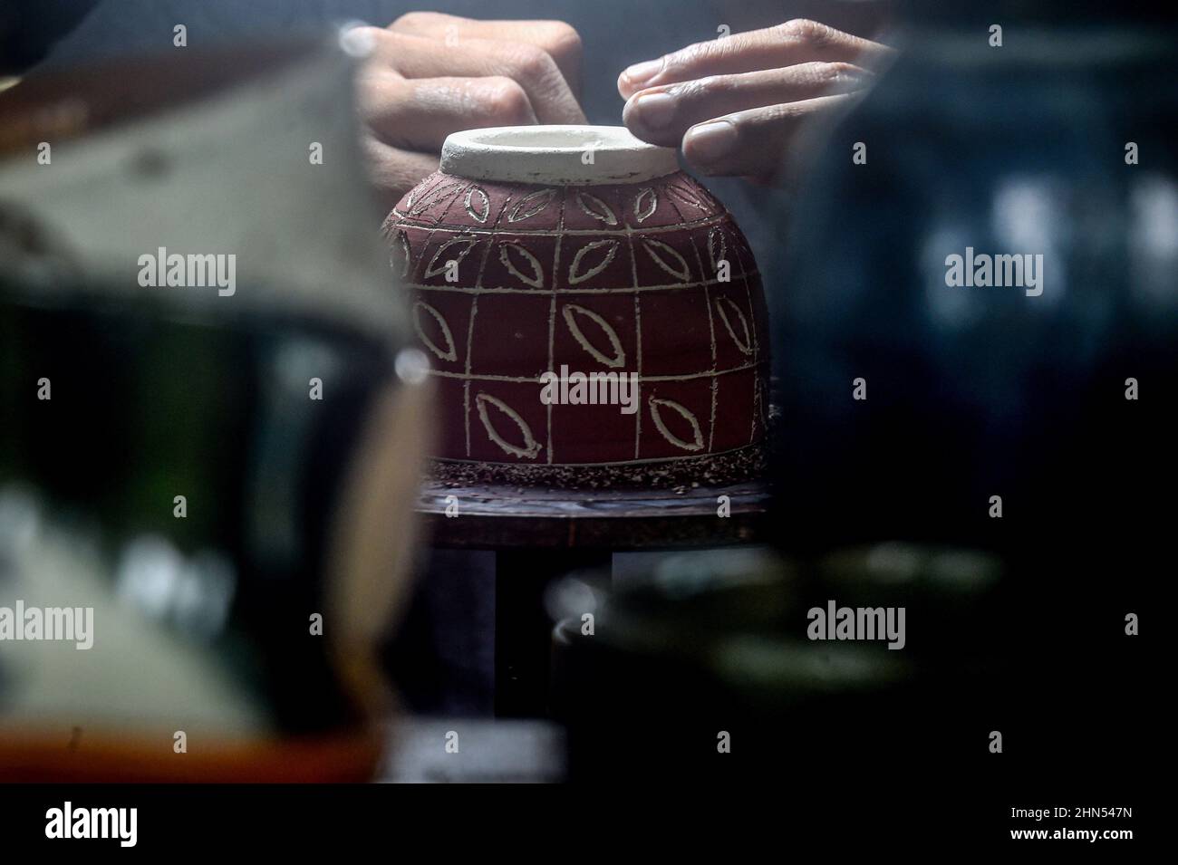 West Java, Indonesia. 14th Feb, 2022. A craftsman carves a pottery at a workshop in Depok, West Java, Indonesia, Feb. 14, 2022. Credit: Agung Kuncahya B./Xinhua/Alamy Live News Stock Photo