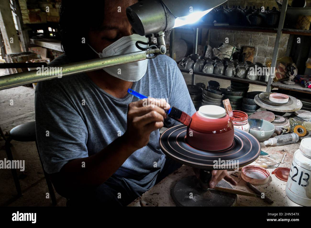 West Java, Indonesia. 14th Feb, 2022. A craftsman paints a pottery at a workshop in Depok, West Java, Indonesia, Feb. 14, 2022. Credit: Agung Kuncahya B./Xinhua/Alamy Live News Stock Photo