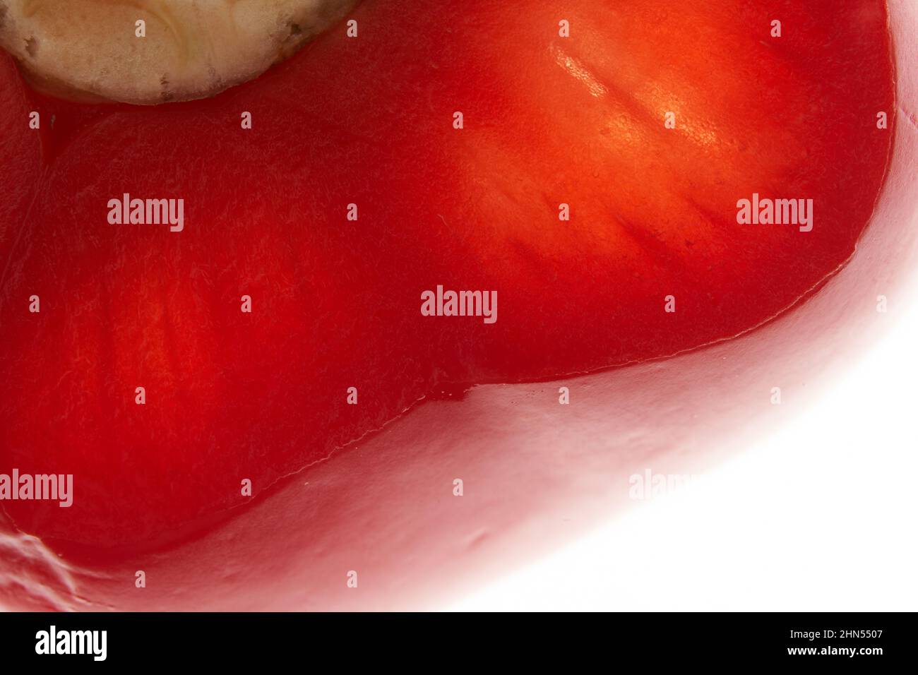 Part of a piece of sweet red bell pepper. Detail of half a red pepper on an isolated white background. High quality photo Stock Photo