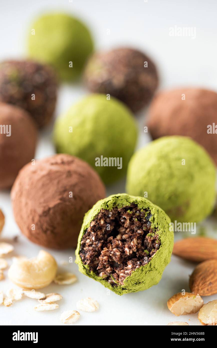Vegan chocolate truffles with nuts and green tea Matcha. Closeup view. Truffle missing bite Stock Photo