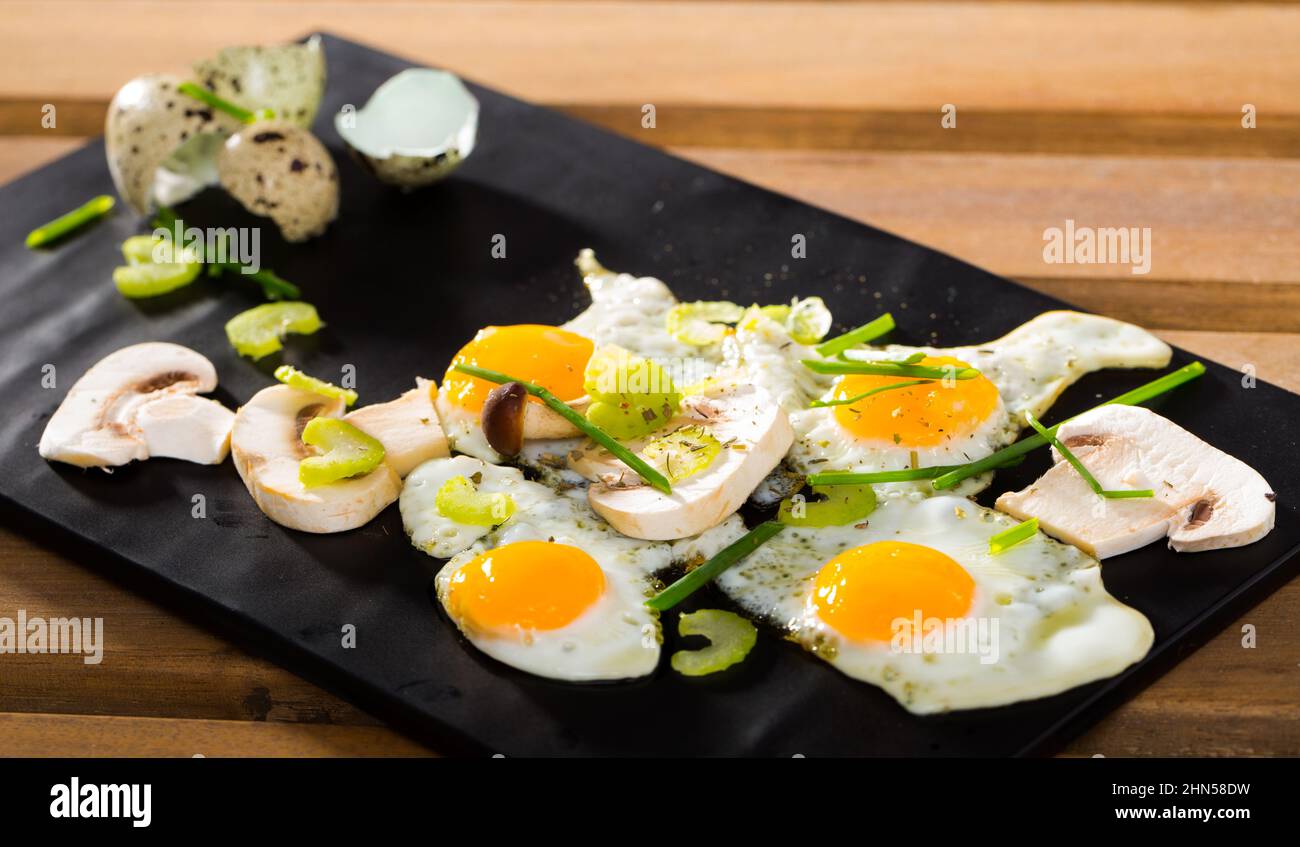 Fried quail eggs with champignons Stock Photo