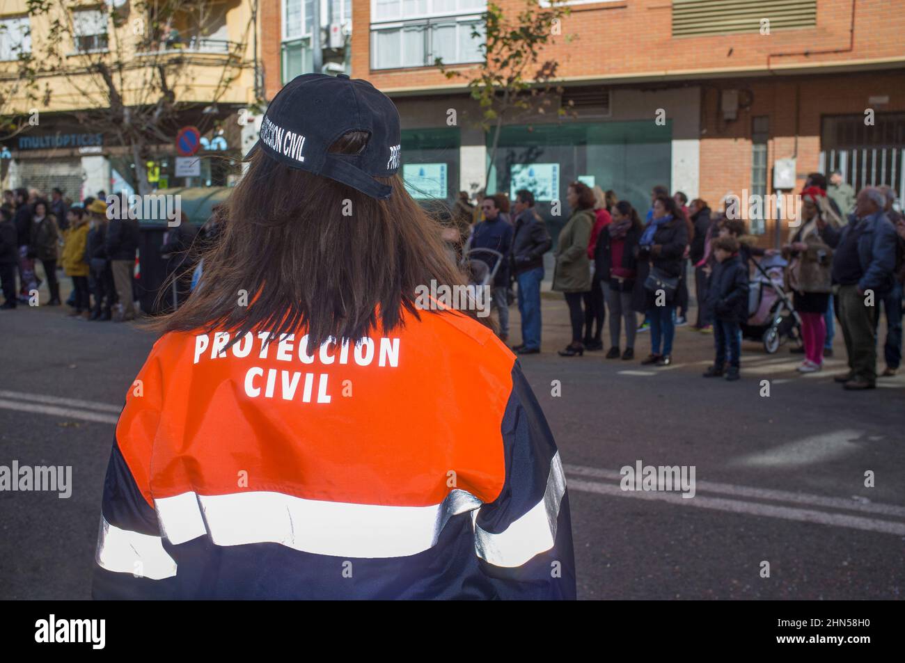 Badajoz, Spain - Feb 13, 2018: San Roque comparsas parade. Woman civil defense agent watching event. Badajoz Carnival, Festivity of International Tour Stock Photo