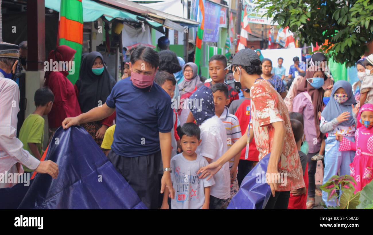 Jakarta, Indonesia - 11 19 2020: Muslims working together to open tarpaulins during Eid al-Adha celebrations Stock Photo