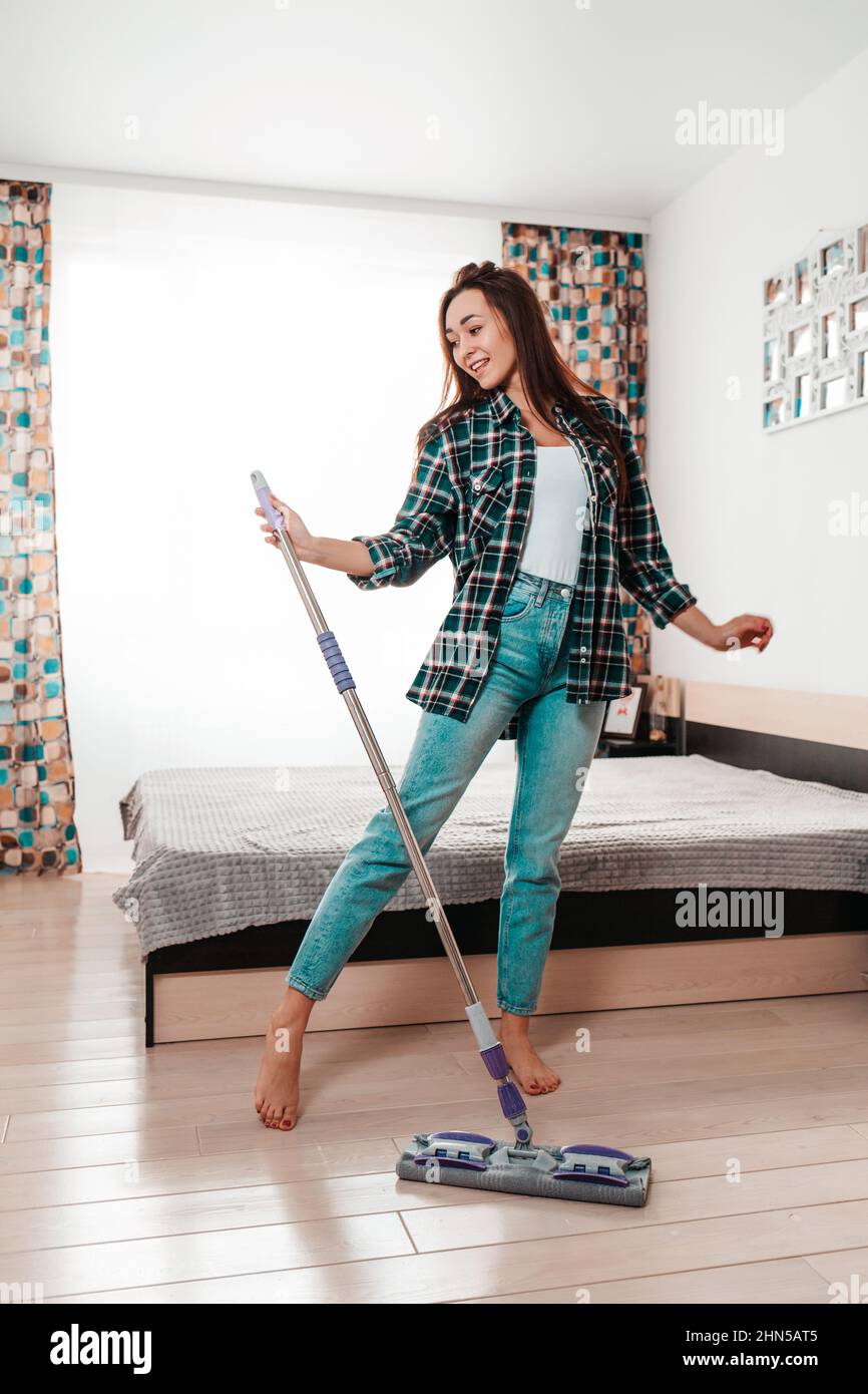 Cleaning. Beautiful young woman doing cleaning, dancing with a
