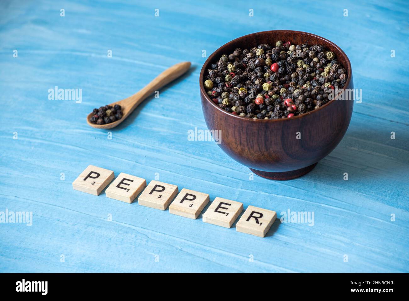 peppercorns on wooden bowl Stock Photo